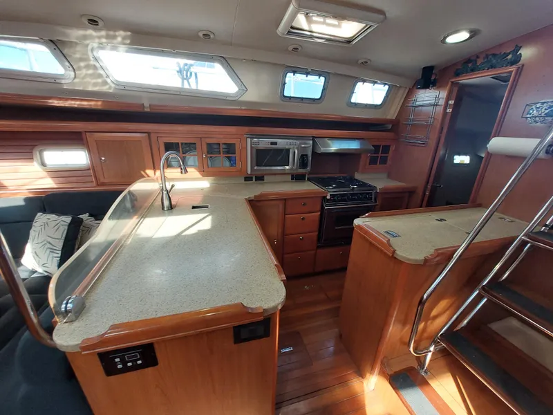 Slide: The Image of Interior of 2009 Hunter 49 yacht with modern kitchen and wooden cabinetry. - 14