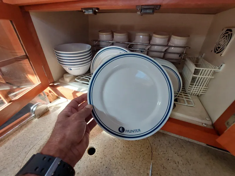 Slide: The Image of Hand holding Hunter plate in a kitchen cabinet, Hunter 49 model, 2009. - 16