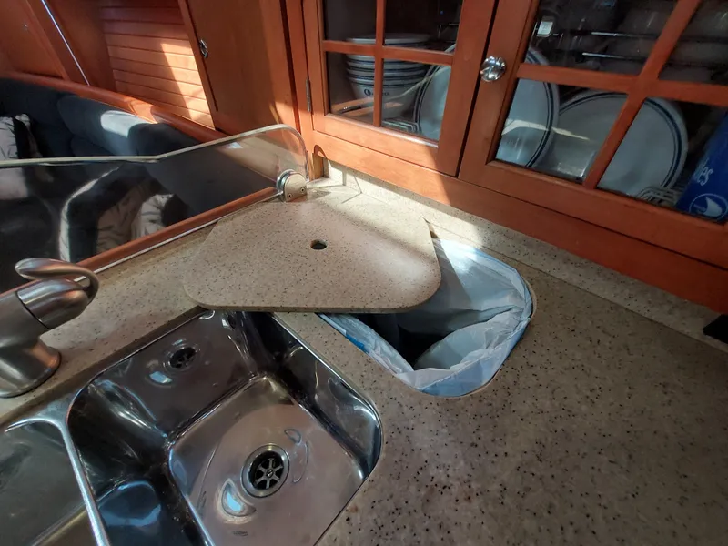 Slide: The Image of 2009 Hunter 49 yacht kitchen with sink, countertop, and wooden cabinets. - 18