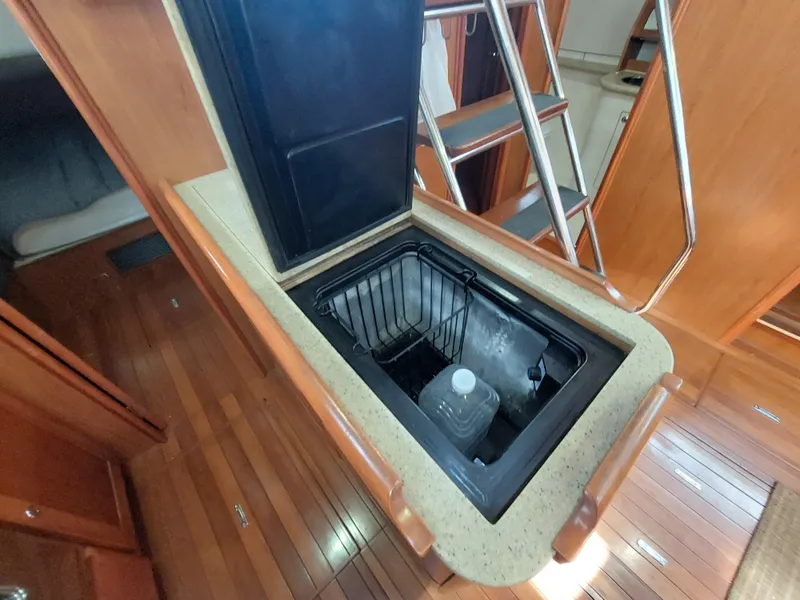 Slide: The Image of 2009 Hunter 49 yacht interior with open fridge and wooden flooring. - 20