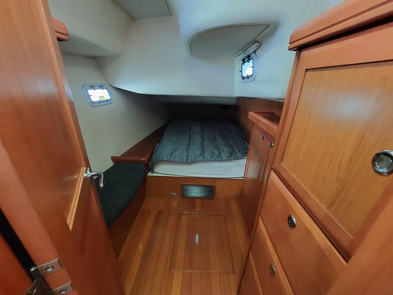 Slide: The Image of Cozy cabin interior of 2009 Hunter 49 sailboat with wooden furnishings and bed. - 24