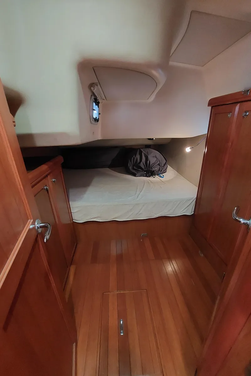 Slide: The Image of 2009 Hunter 49 yacht cabin with wooden interior and cozy bed. - 27