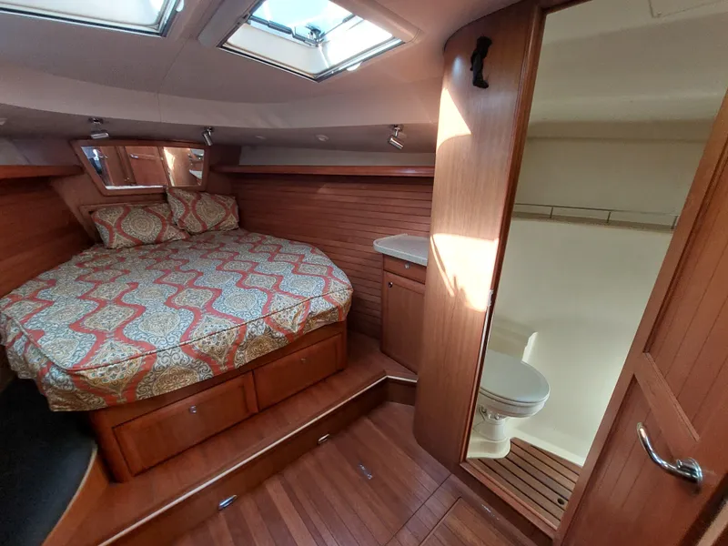 Slide: The Image of 2009 Hunter 49 yacht interior with cozy bed and compact bathroom. - 33
