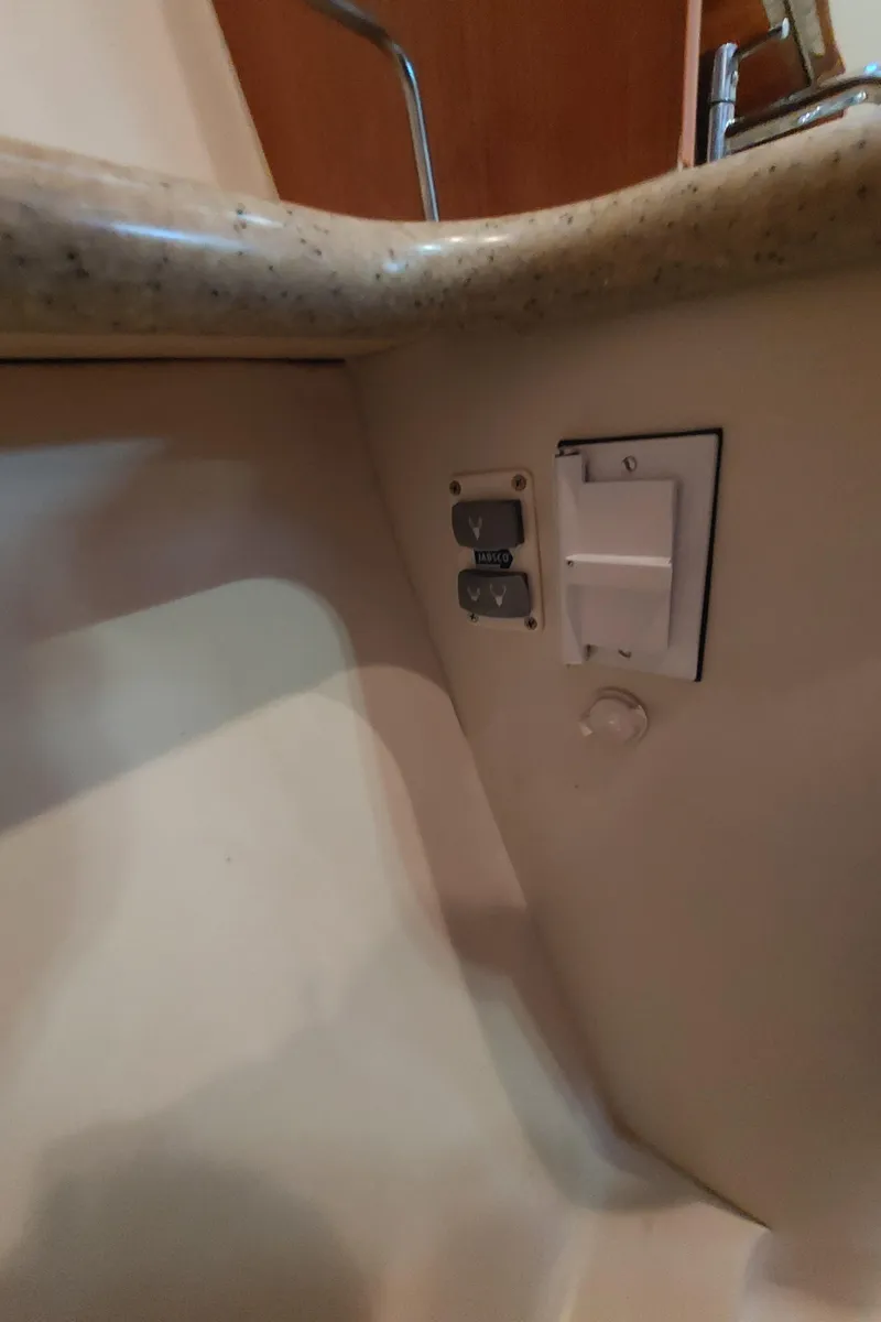 Slide: The Image of Electrical outlet and switch under countertop in 2009 Hunter 49 boat. - 39