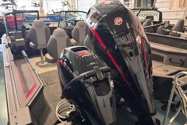 Slide: The Image of 2025 Alumacraft Trophy 185X Sport boat with dual outboard motors in showroom. - 2