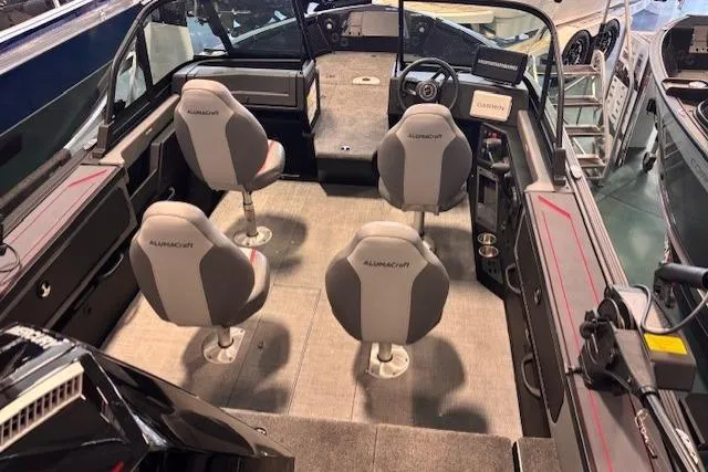 Slide: The Image of 2025 Alumacraft Trophy 185X Sport boat interior with four seats and modern dashboard. - 5