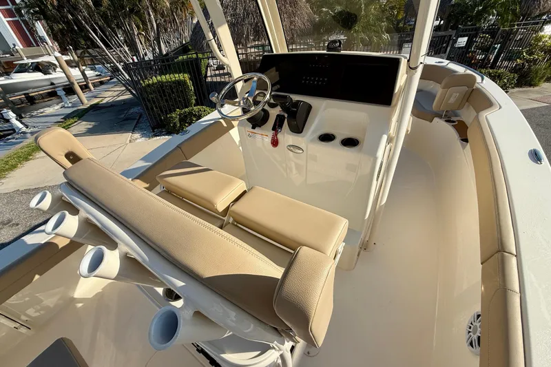 Slide: The Image of 2025 Scout 215 XSF boat interior with beige seating and steering console. - 11