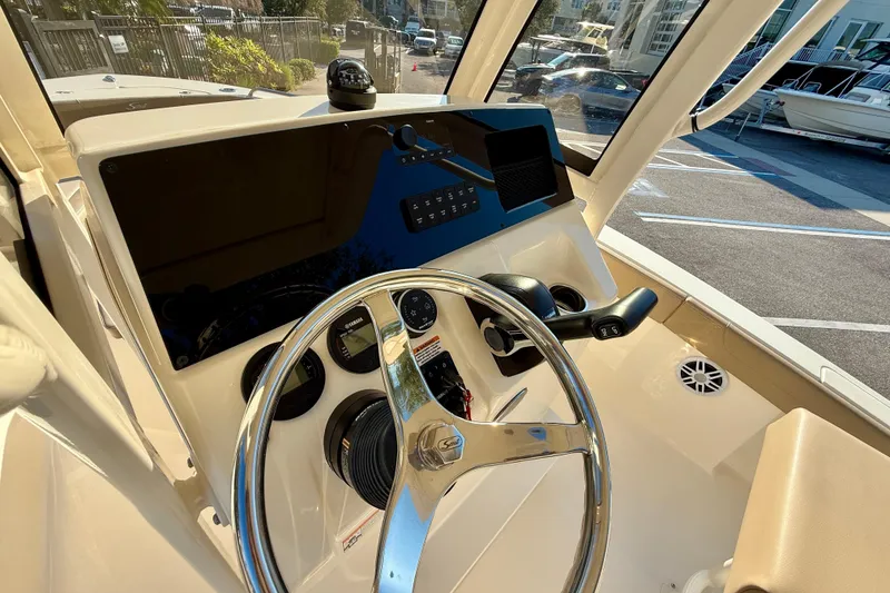 Slide: The Image of 2025 Scout 215 XSF boat dashboard with steering wheel and control panel. - 13