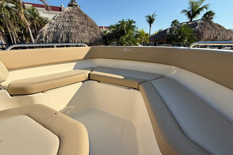 Slide: The Image of 2025 Scout 215 XSF boat interior with beige seating, tropical background. - 16