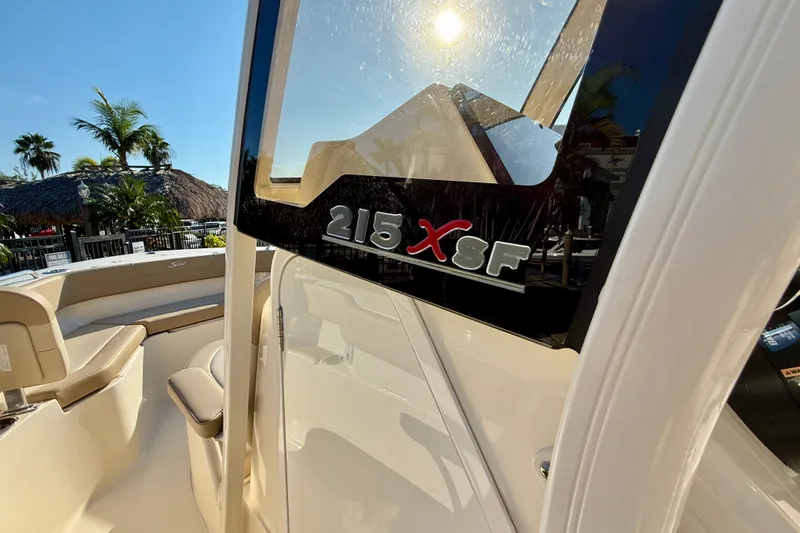 Slide: The Image of 2025 Scout 215 XSF boat interior with sunlit seating and palm trees. - 20