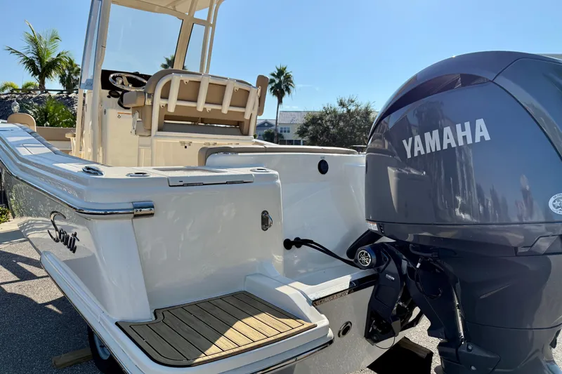 Slide: The Image of 2025 Scout 215 XSF boat with Yamaha engine, docked under clear blue sky. - 4