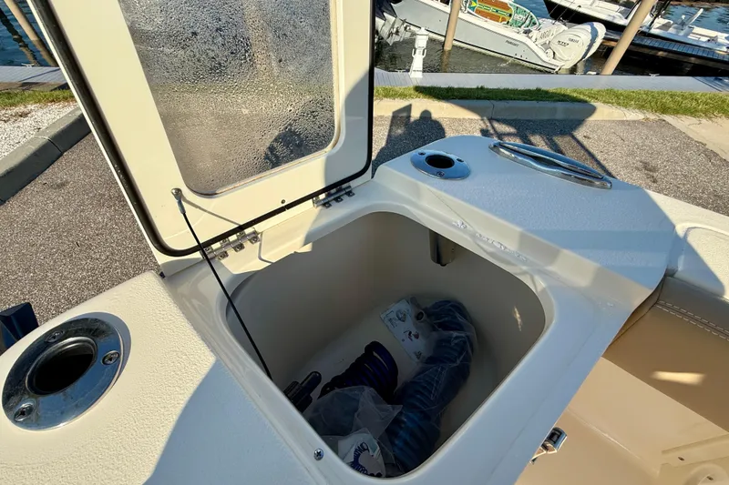Slide: The Image of Open storage compartment on 2025 Scout 215 XSF boat at marina. - 8
