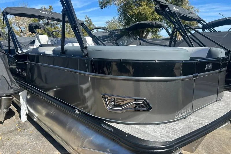 The Image of 2025 Avalon Catalina Quad Lounger pontoon boat, sleek design, black exterior, outdoor setting. - 0