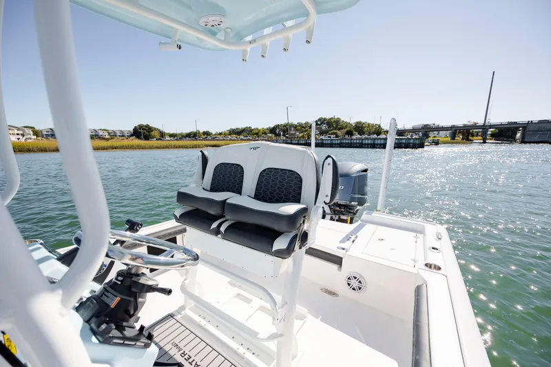 Slide: The Image of 2024 Tidewater 2300 Carolina Bay boat on water, featuring sleek seating and modern controls. - 14