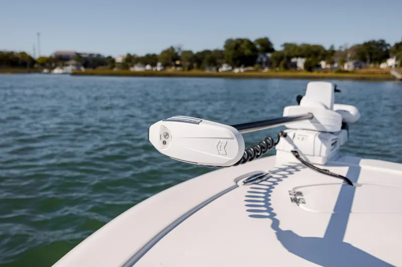 Slide: The Image of 2024 Tidewater 2300 Carolina Bay boat on calm water, featuring advanced trolling motor. - 16