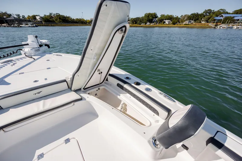 Slide: The Image of 2024 Tidewater 2300 Carolina Bay boat with open storage compartment on calm water. - 18