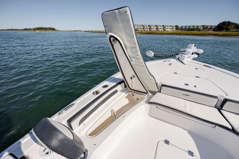 Slide: The Image of 2024 Tidewater 2300 Carolina Bay boat interior with open storage compartment on calm water. - 19