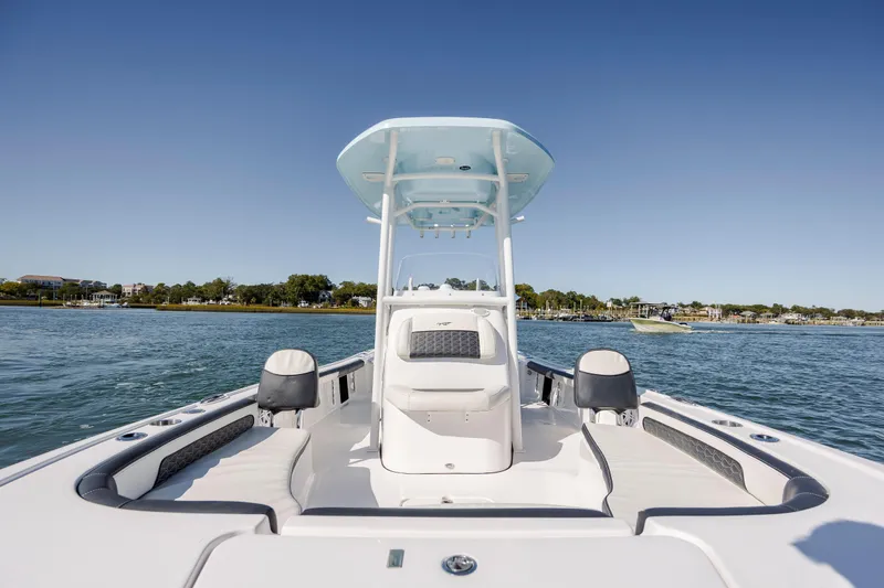 Slide: The Image of 2024 Tidewater 2300 Carolina Bay boat on calm water, featuring sleek design and spacious seating. - 20