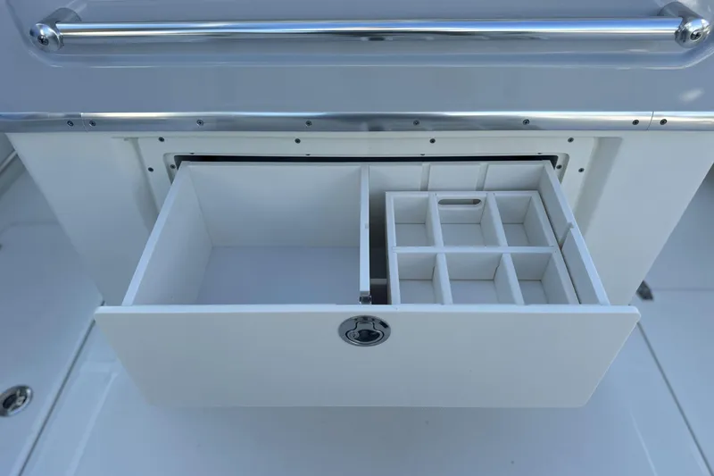 Slide: The Image of 2026 Cobia 285 Open Center Console storage drawer with compartments, featuring sleek design and functionality. - 20
