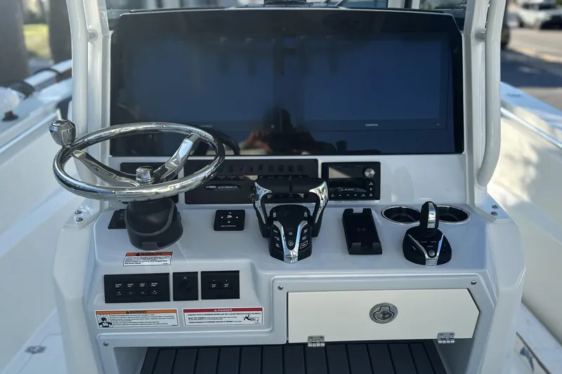 Slide: The Image of Center console of 2026 Cobia 285 Open, featuring steering wheel and controls. - 25