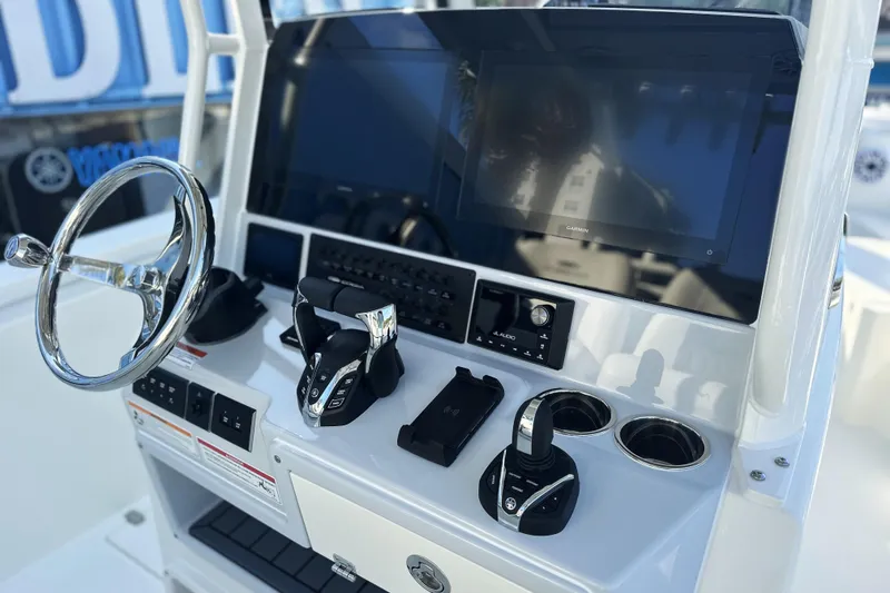 Slide: The Image of 2026 Cobia 285 Open Center Console helm with steering wheel and Garmin display. - 26