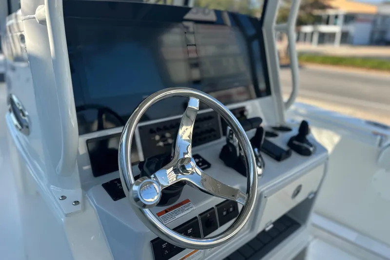 Slide: The Image of 2026 Cobia 285 Open Center Console boat steering wheel and control panel. - 28