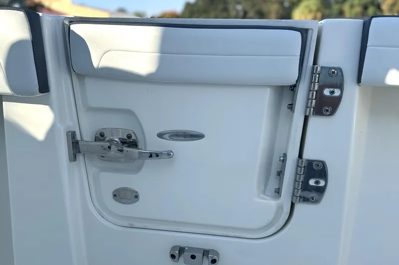 Slide: The Image of 2026 Cobia 285 Open Center Console boat door with stainless steel hinges and latch. - 35
