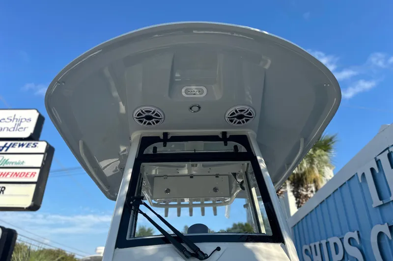 Slide: The Image of 2026 Cobia 285 Open Center Console boat with speakers, under a clear blue sky. - 36