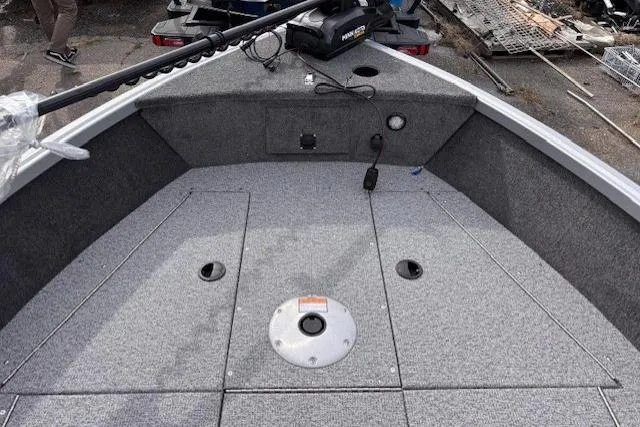 Slide: The Image of 2024 Alumacraft Voyageur 175 Sport boat interior with gray carpeted deck. - 8