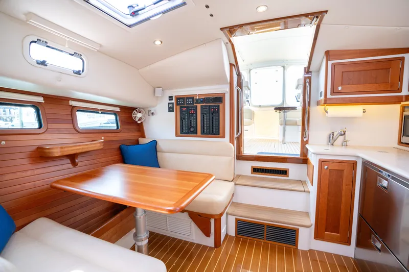 Slide: The Image of 2017 MJM 40z Downeast yacht docked at marina, showcasing spacious deck and sleek design. - 11