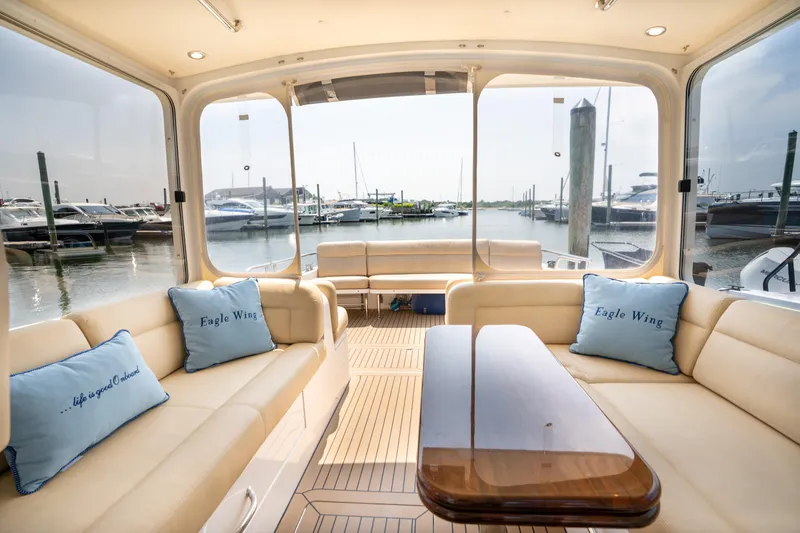 Slide: The Image of 2017 MJM 40z Downeast yacht interior with beige seating and wooden table. - 16