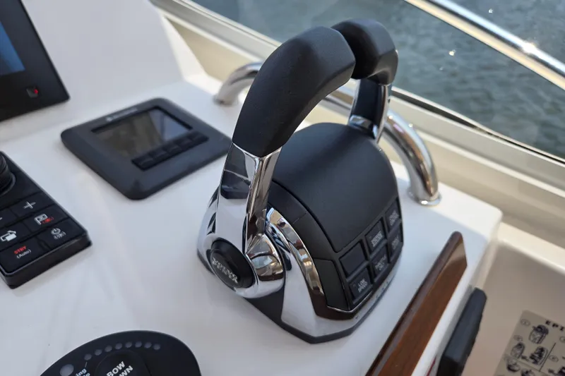 Slide: The Image of Throttle controls on a 2017 MJM 40z Downeast boat dashboard, featuring modern navigation equipment. - 27