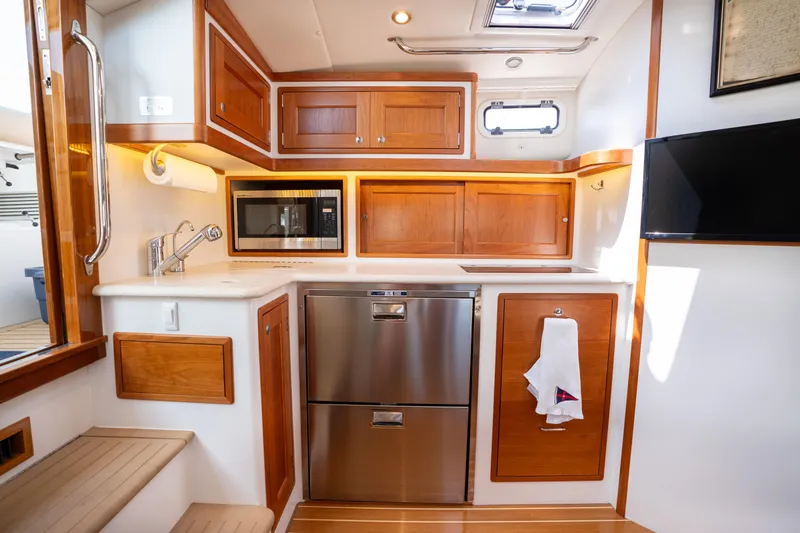 Slide: The Image of 2017 MJM 40z Downeast yacht kitchen with wood cabinets, stainless appliances, and modern fixtures. - 29