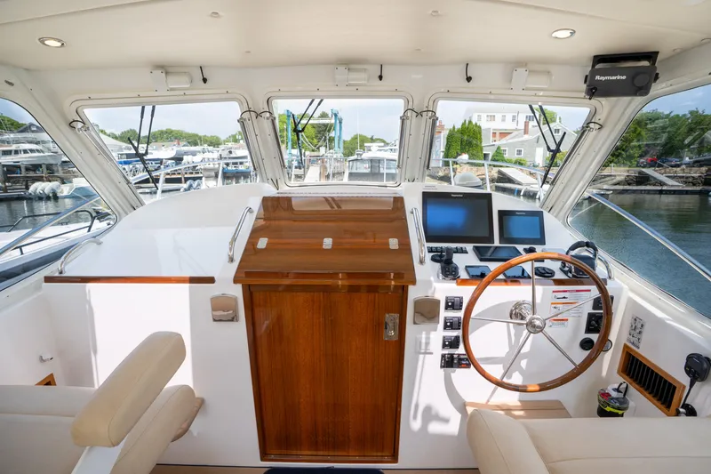 Slide: The Image of 2017 MJM 40z Downeast boat with spacious deck and beige seating at marina. - 7