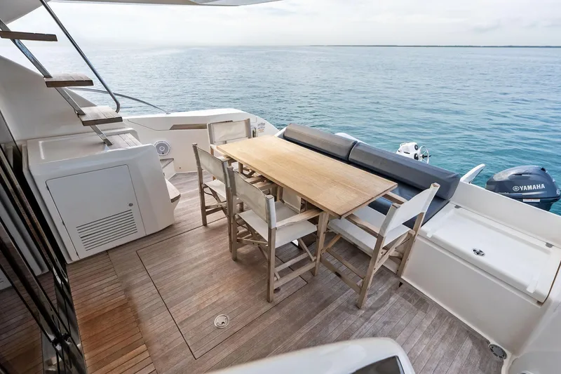 Slide: The Image of 2018 Ferretti Yachts 550 deck with dining area overlooking the ocean. - 32