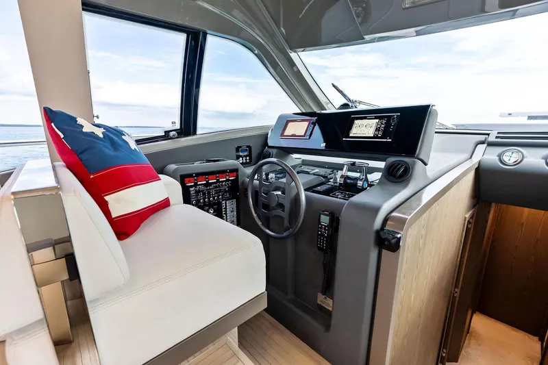 Slide: The Image of 2018 Ferretti Yachts 550 helm with modern controls and American flag pillow. - 66