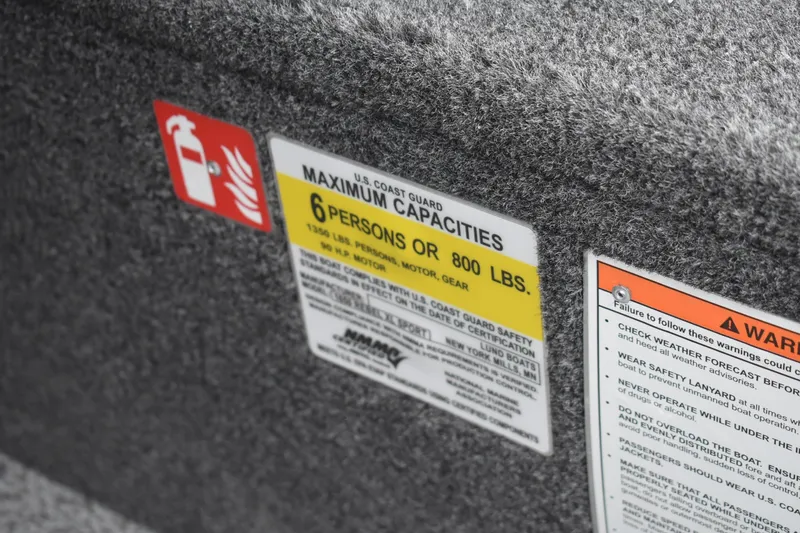 Slide: The Image of Safety labels on 2026 Lund 1650 Rebel XL Sport boat, indicating capacity and warnings. - 10