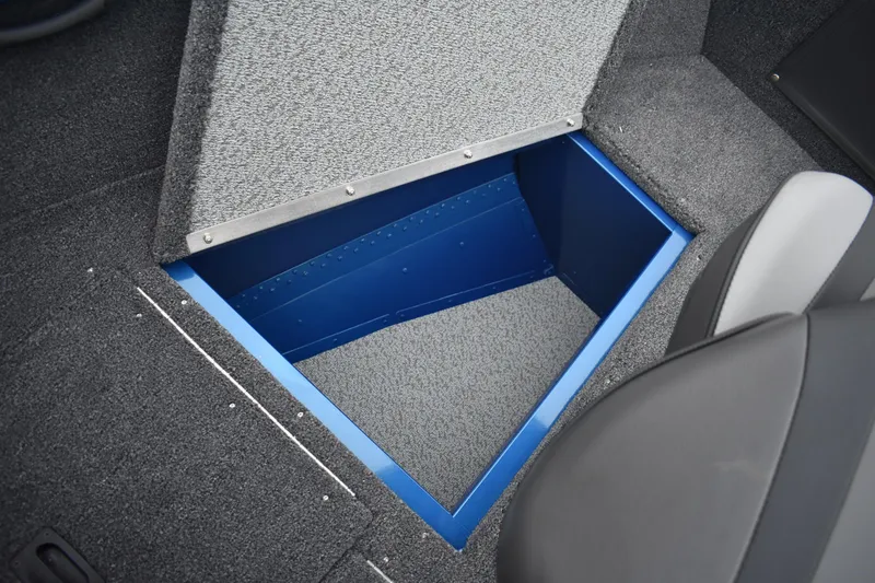 Slide: The Image of 2026 Lund 1650 Rebel XL Sport boat storage compartment with open lid. - 19