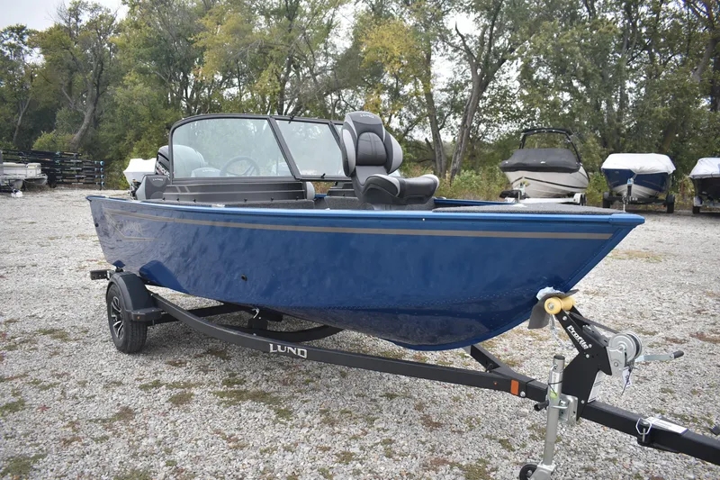 Slide: The Image of 2026 Lund 1650 Rebel XL Sport boat on trailer, parked outdoors. - 2