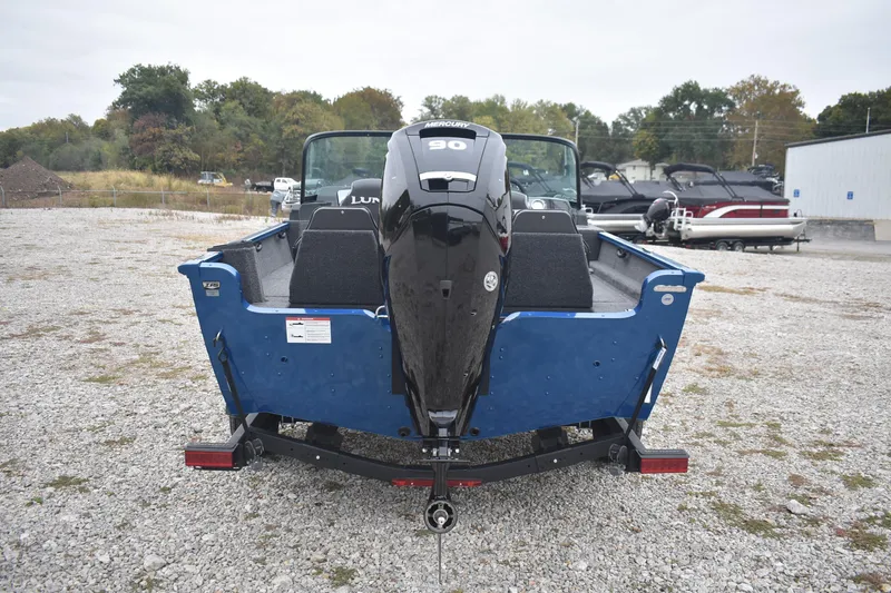 Slide: The Image of 2026 Lund 1650 Rebel XL Sport boat with Mercury 90 engine, parked on gravel. - 6
