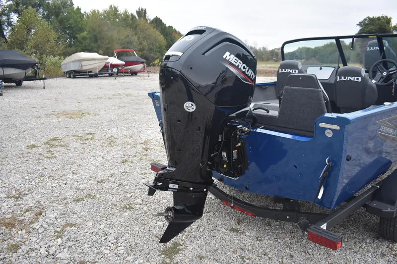 Slide: The Image of 2026 Lund 1650 Rebel XL Sport boat with Mercury outboard motor in a gravel lot. - 7