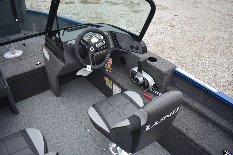 Slide: The Image of 2026 Lund 1650 Rebel XL Sport boat interior with steering wheel and seating. - 9