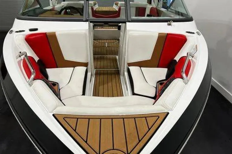 Slide: The Image of 2019 Nautique Super Air Nautique 210 boat interior with red and white seating. - 3