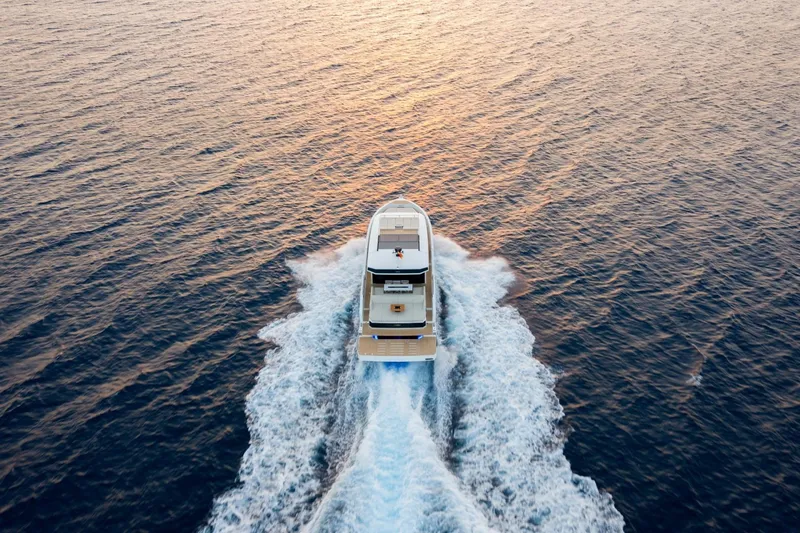Slide: The Image of Aerial view of 2026 De Antonio Yachts D60 cruising on open water at sunset. - 8