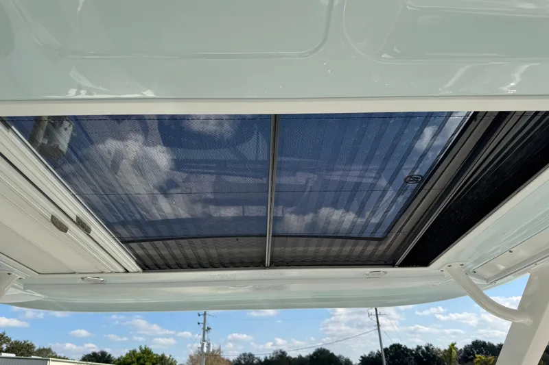 Slide: The Image of 2024 Chaparral 280 OSX boat with open sunroof, showcasing clear sky and clouds. - 42