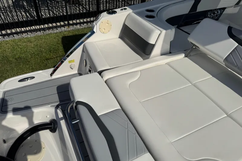 Slide: The Image of 2024 Chaparral 280 OSX boat interior with white cushioned seating and cup holders. - 45