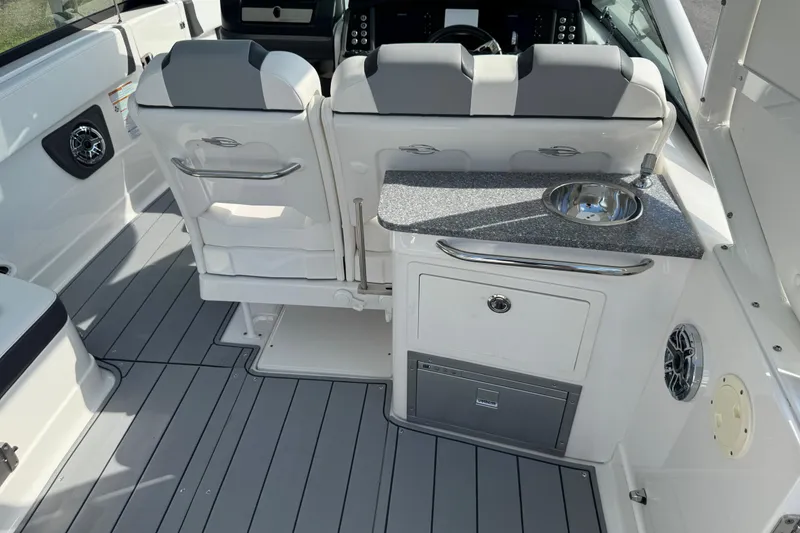 Slide: The Image of 2024 Chaparral 280 OSX boat interior with seating, sink, and modern dashboard. - 46