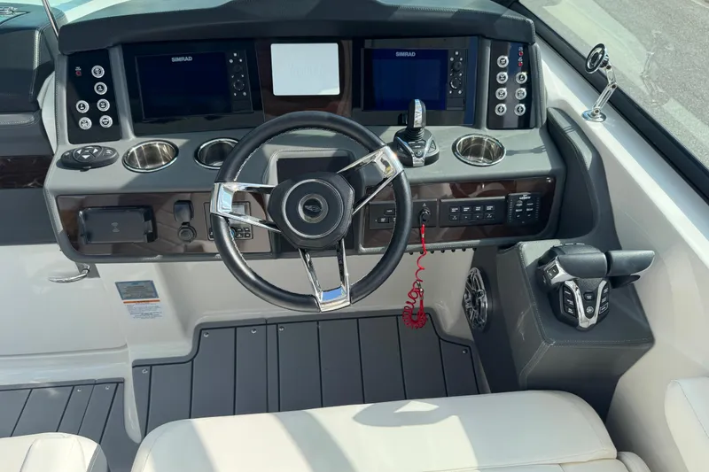 Slide: The Image of 2024 Chaparral 280 OSX boat helm with steering wheel, controls, and dual Simrad displays. - 52