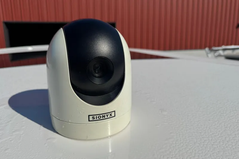 Slide: The Image of SIONYX camera on 2024 Chaparral 280 OSX boat deck, with red building background. - 64