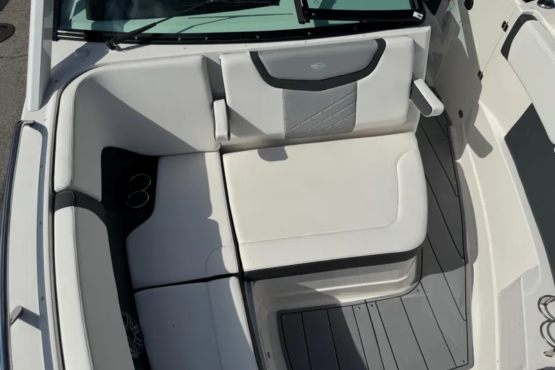 Slide: The Image of 2024 Chaparral 280 OSX boat interior with white cushioned seating and cup holders. - 68